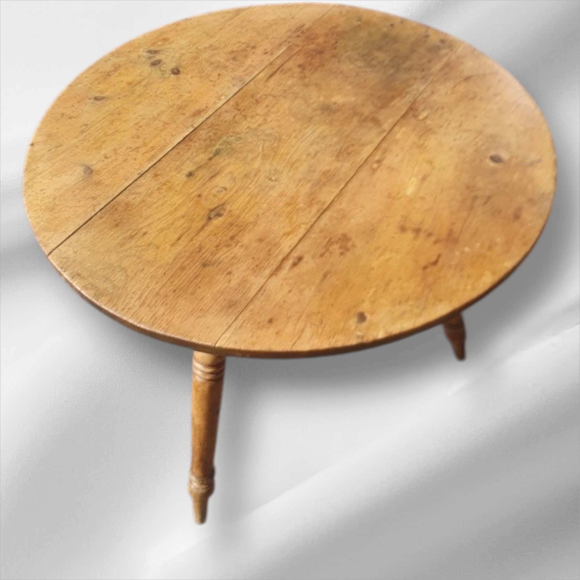 This is a beautiful 19th-century antique pine cricket table. It has a tripod base and a round top. The table shows a rich patina and rustic charm. This style is typical of Victorian country furniture